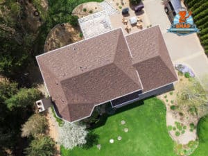 Aerial view of a home with brown shingles.