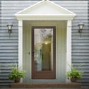 A home entryway with an overhand and a glass storm door.