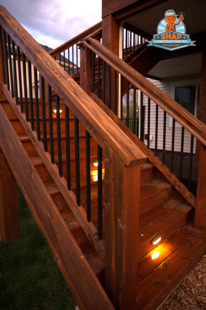 A wood staircase leading to an elevated deck on a home.