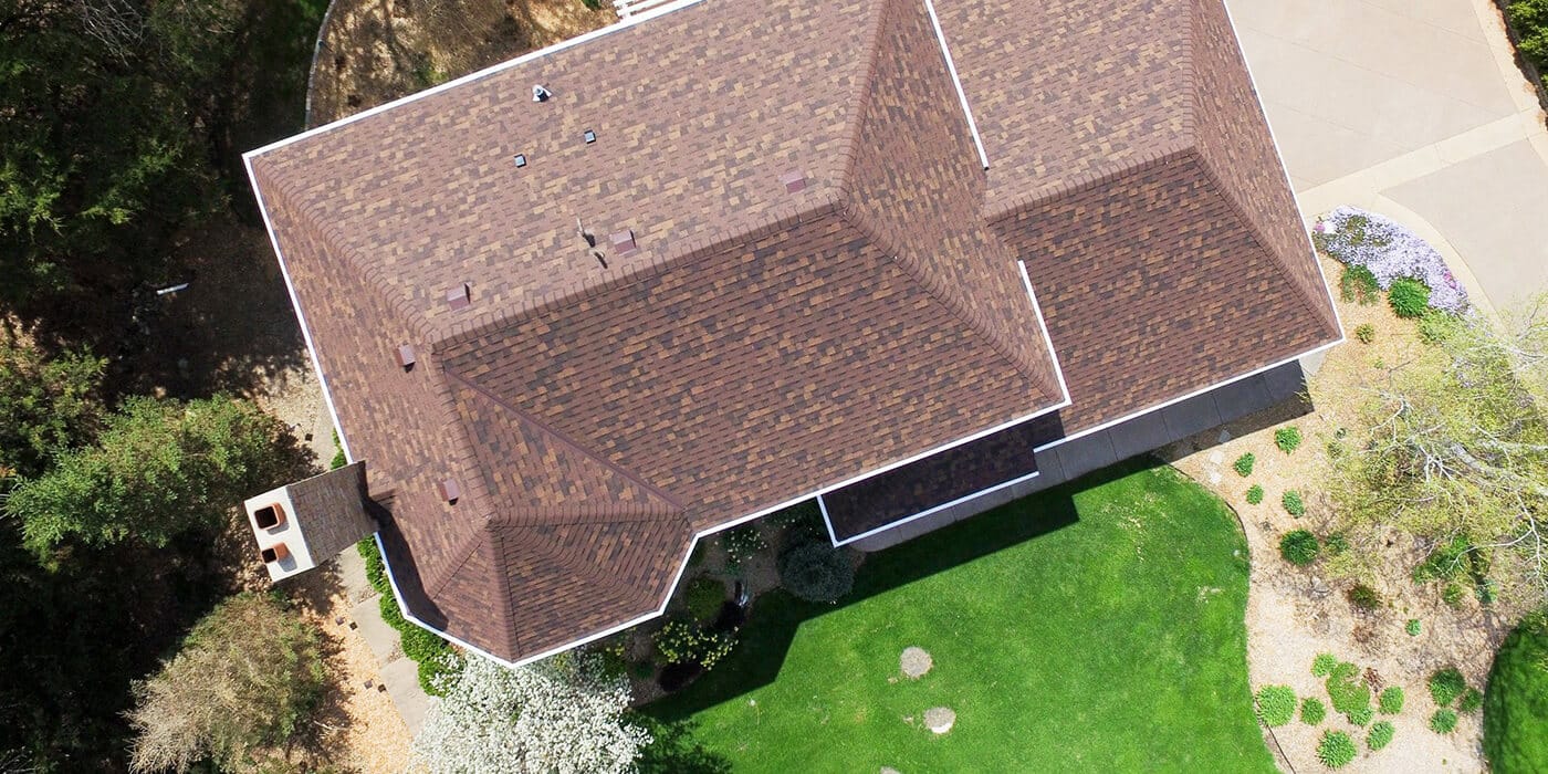 An aerial image of a home with a brown shingle roof.