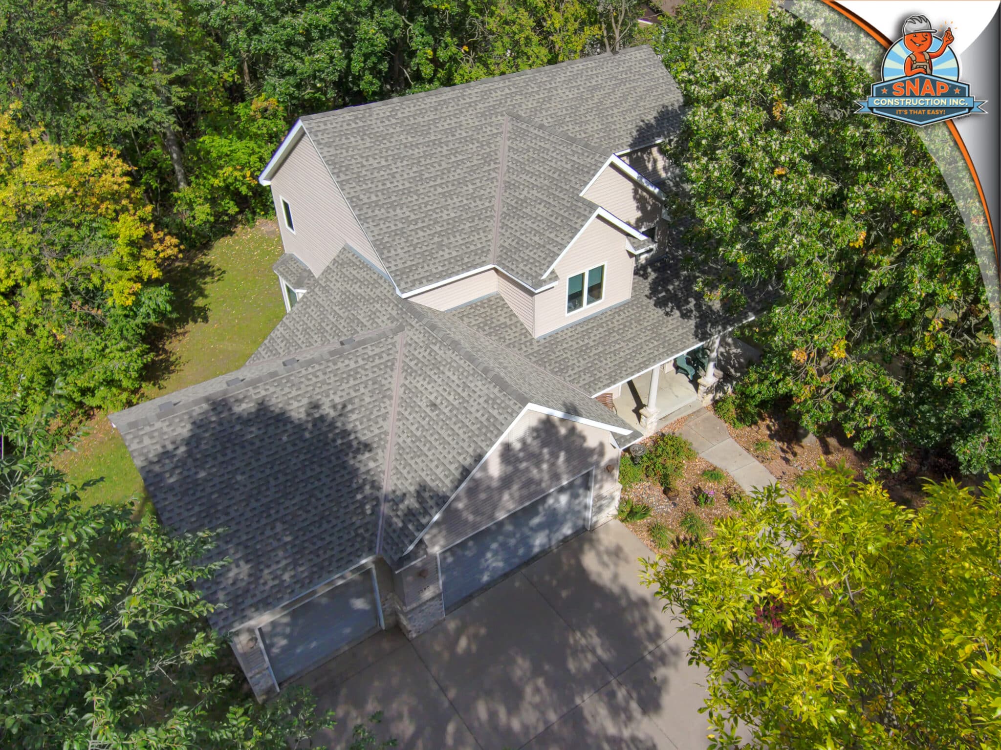 Snap Construction Roofing Contractor in Bloomington MN showcases new asphalt shingle roof on two-story suburban home surrounded by trees