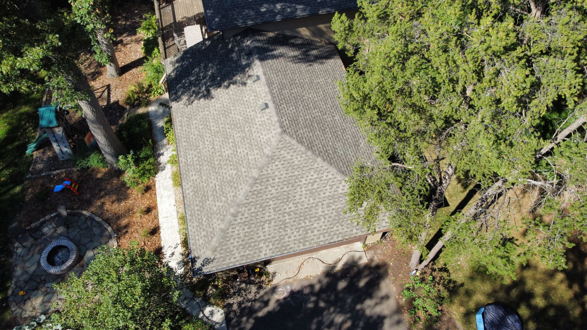 Aerial view of shingle roof on a suburban home with trees, by Snap Construction, roofing and siding contractor near me in Bloomington MN